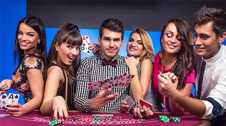 Un gruppo di giovani player posano con aria divertita su un tavolo del Blackjack Party.