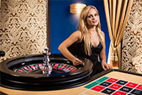Una croupier Evolution Gaming siede ad un tavolo roulette live.