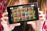 Uno smartphone con un gioco casinò tenuto in mano da una donna.