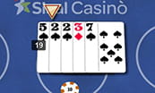 Un dettaglio su un tavolo blackjack con una mano composta da cinque carte per un punteggio totale di 19.